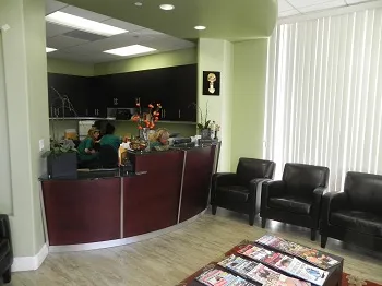 Dr. Margossian's waiting room for patients with reading materials and chairs in front of the front desk